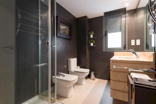 a bathroom with a toilet and a glass shower at MintyStay - Felipe Campos in Madrid