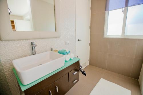 a bathroom with a white sink and a mirror at Dream Punta Cana Beachfront Apartment - 4-Bedroom Penthouse with Rooftop BBQ & Ocean Views in Punta Cana