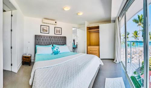 a bedroom with a large bed and a large window at Dream Punta Cana Beachfront Apartment - 4-Bedroom Penthouse with Rooftop BBQ & Ocean Views in Punta Cana