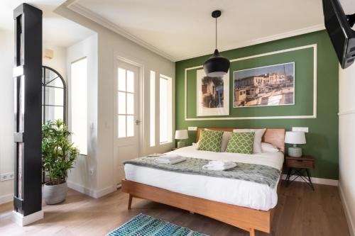 una camera da letto con pareti verdi e un grande letto di Minty Stay - Andrés Borrego a Madrid