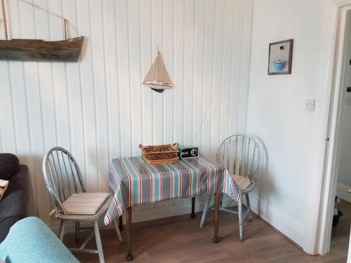 a dining room table with two chairs and a camera on it at Claremont House Holiday Apartments in Llandudno