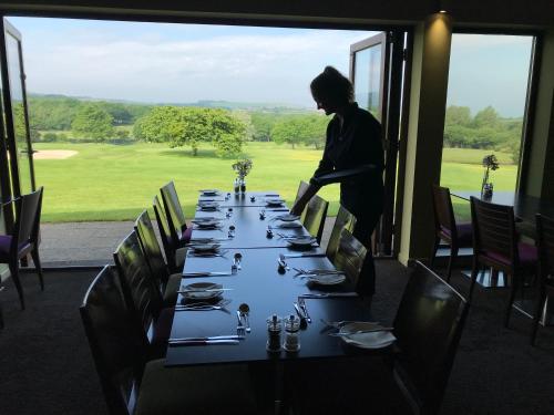 a person standing in front of a long table at Lanhydrock Hotel & Golf Club in Bodmin