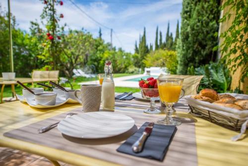 una mesa con platos de comida y bebidas. en La Demeure de Cybele - chambres d'hôtes en Drôme Provençale, en Colonzelle