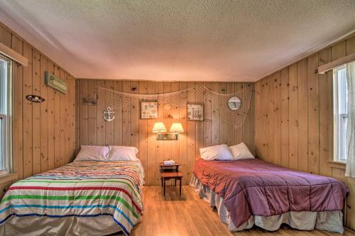 2 camas en una habitación con paredes de madera en Lovely Lake Cabin Boat Rentals and On-Site Bar, en Dent