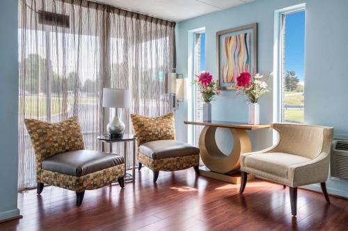 a living room with chairs and a table with a desk at Rodeway Inn in Anderson