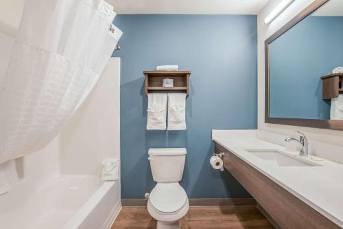 a bathroom with a toilet and a sink and a tub at WoodSpring Suites Chicago Midway in Burbank