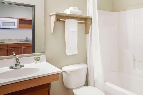 a bathroom with a white toilet and a sink at WoodSpring Suites Manassas Battlefield Park I-66 in Manassas