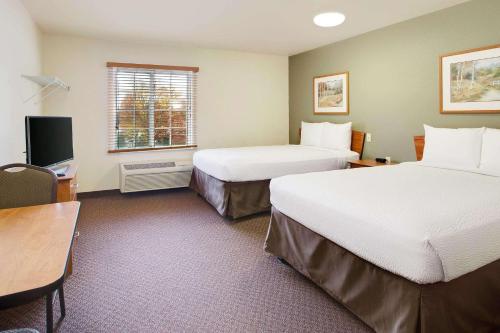 a hotel room with two beds and a desk at WoodSpring Suites Chesapeake-Norfolk South in Chesapeake