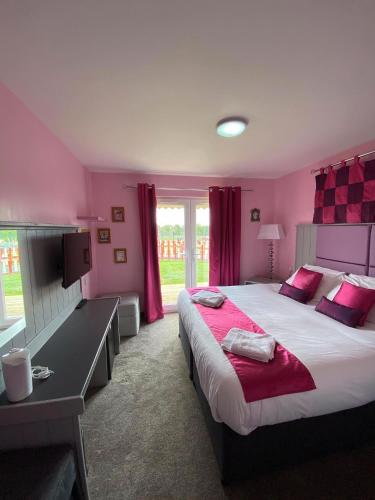a bedroom with a large bed with red curtains at Gulliver's Valley, M1, JCT 31 in Rotherham