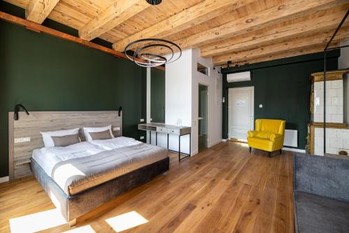 a bedroom with a bed and a yellow chair at Oysters & Bubbles Gastro Hotel. Rynok square in Lviv