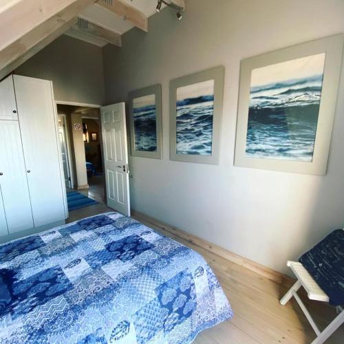 a bedroom with a bed and three pictures on the wall at Kaiha (Witsand, Western Cape) in Witsand