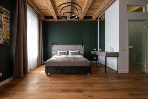 a bedroom with a bed and a green wall at Oysters & Bubbles Gastro Hotel. Rynok square in Lviv