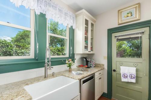 a kitchen with a sink and a green door at Historic Prescott Home with Yard Walk Downtown! in Prescott