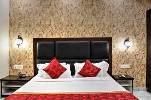 a bedroom with a large bed with red pillows at HOTEL HILL VIEW in Dehradun