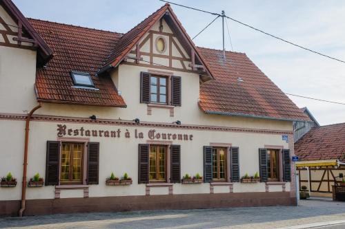 a building with a sign on the side of it at Hôtel Restaurant La Couronne in Roppenheim