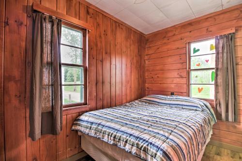 a bed in a wooden room with two windows at Lake Retreat Fire Pit, Boat Rentals, BBQ! in Dent