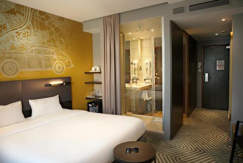 a bedroom with a white bed and a bathroom at Mercure Warszawa Grand in Warsaw