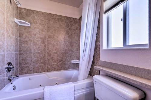 a bathroom with a tub and a toilet and a window at Inviting Retreat with Patio Less Than 1 Mi to Colorado River in Bullhead City