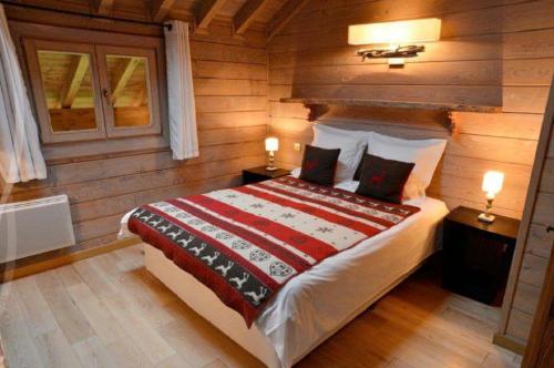 - une chambre avec un lit dans une cabane en rondins dans l'établissement Biches du Plantin, à Les Allues