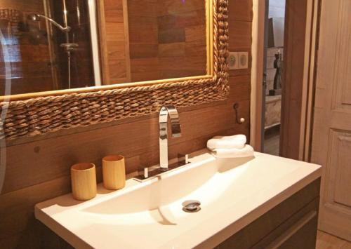La salle de bains est pourvue d'un lavabo blanc et d'un miroir. dans l'établissement Biches du Plantin, à Les Allues