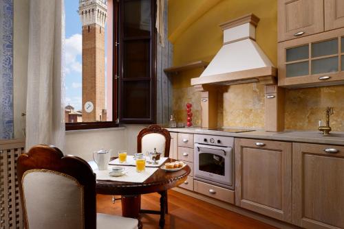 cocina con mesa, fregadero y fogones en Piazza del Campo Honeymoon Suite, en Siena
