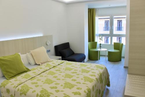 Habitación de hotel con cama y silla en Rambla Alicante Contactless, en Alicante