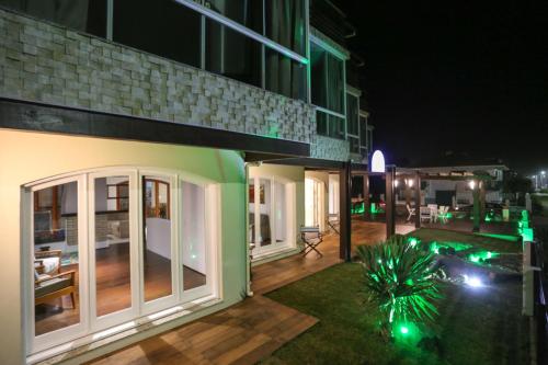 a building with a patio at night at Pousada Praia Do Meio in Torres