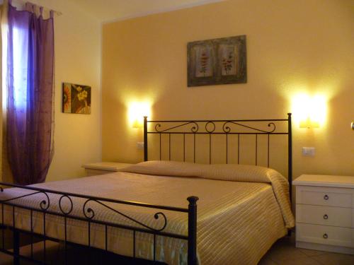 ein Schlafzimmer mit einem Bett und zwei Lampen an der Wand in der Unterkunft CASADELFARO Primo Piano 600mt dalla spiaggia in Olbia