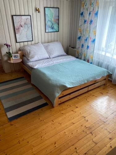 a bed in a bedroom with a wooden floor at U Eli in Wambierzyce