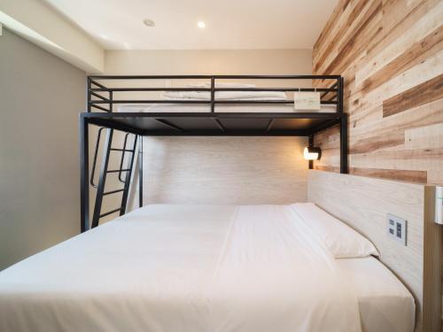 a bedroom with a bunk bed with a wooden wall at Super Hotel Shinagawa Aomono-Yokocho in Tokyo