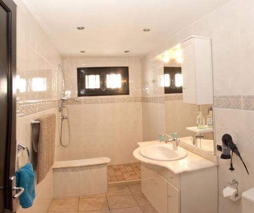 ein weißes Bad mit einem Waschbecken und einer Dusche in der Unterkunft Casa Princesa Ico in Tías