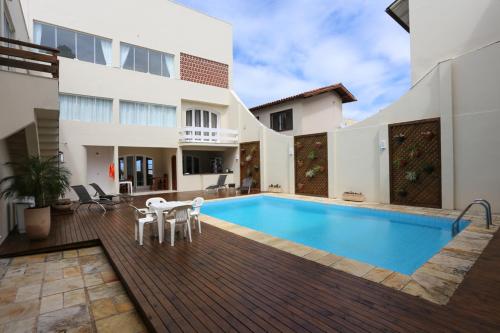 a villa with a swimming pool and a house at Pousada Praia Do Meio in Torres
