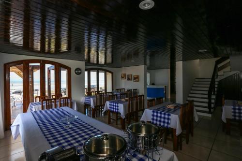 a restaurant with blue and white tables and chairs at Pousada Praia Do Meio in Torres