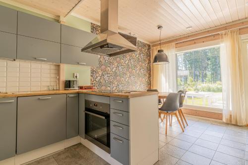 a kitchen with a stove top oven next to a table at Saimaa Life Apartments in Imatra