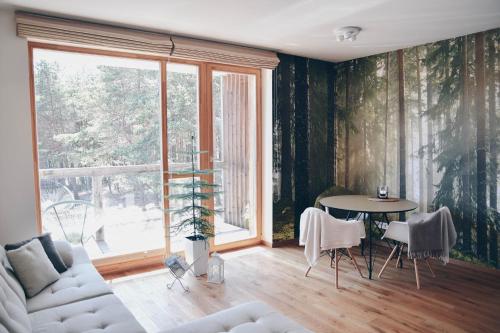 Hygge style apartment Nida في نيدا: غرفة معيشة مع طاولة ونافذة كبيرة