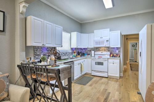 a kitchen with white cabinets and a table and chairs at Updated Ybor City House with Fenced Yard in Tampa