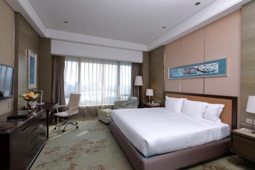 a hotel room with a large bed and a desk at Crowne Plaza Nanjing Jiangning by IHG in Nanjing