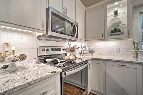 a kitchen with white cabinets and marble counter tops at Hootenanny at Horton Creek Creekside Escape! in Helen
