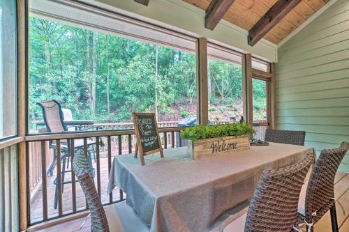 a screened in porch with a table and chairs at Hootenanny at Horton Creek Creekside Escape! in Helen
