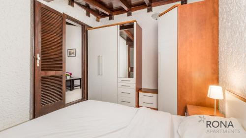 sypialnia z białym łóżkiem i lustrem w obiekcie Rona Holiday Home Ana w Poreču