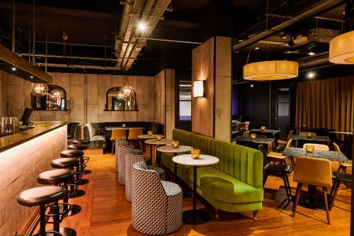 a restaurant with a green couch and tables and chairs at The Chamberlain in London