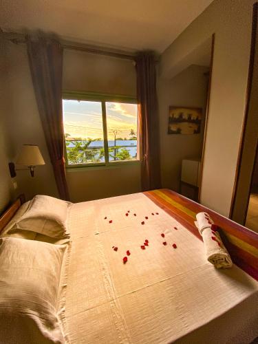 a bedroom with a bed with red rose petals on it at Java Hotel in Toamasina