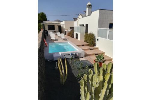 a view of a house with a swimming pool and cactus at Casa felizes in Tías