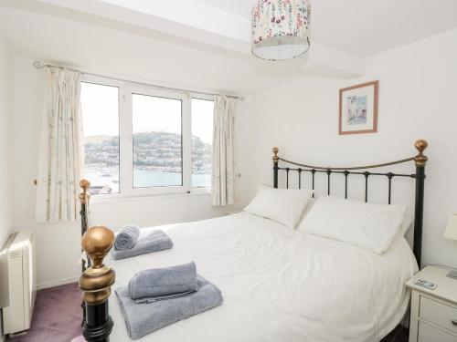 une chambre avec un lit avec une grande fenêtre dans l'établissement 21 Above Town, à Dartmouth