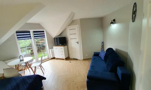 a living room with a blue couch and a table at Pod Żaglami in Dąbki