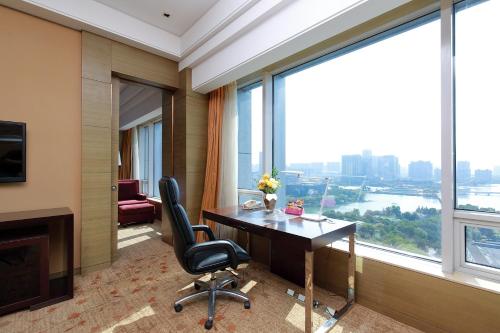 a hotel room with a desk and a large window at Crowne Plaza Nanjing Jiangning by IHG in Nanjing