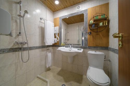 Un baño con inodoro, lavabo y ducha. en Marina Hotel, Sunny Day, en Saints Constantine and Helena