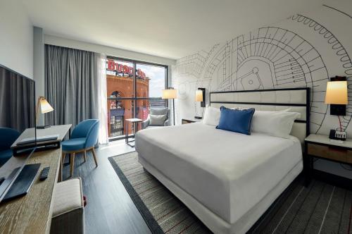 a hotel room with a large bed and a desk at Live! by Loews - St. Louis in Saint Louis