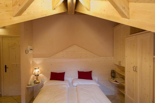 a bedroom with a large white bed with red pillows at Chalet La Rugiada in Bormio