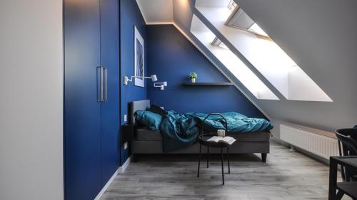 una camera con un letto e una parete blu di GRANO FLATS Gdańsk - Aura II a Danzica